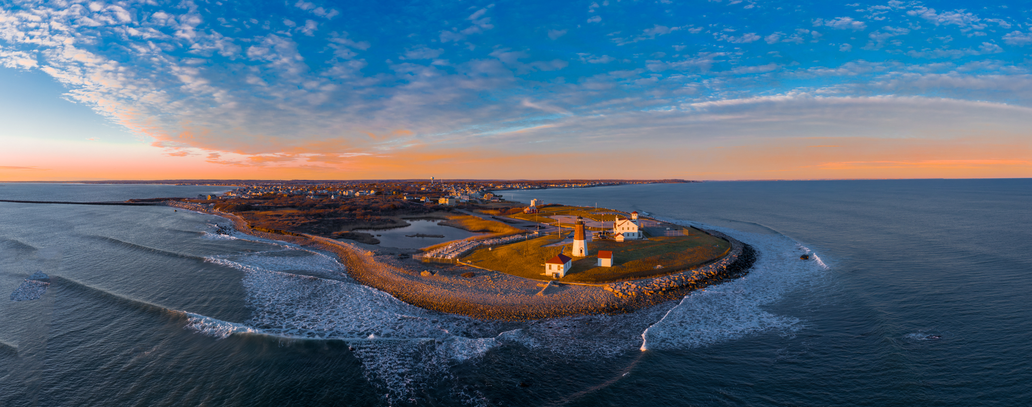 Panoramic drone photo of Point Judith lighthouse and coastline at golden hour